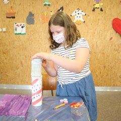 Ein Mädchen erstellt einen selbst gebastelten Leuchtturm.