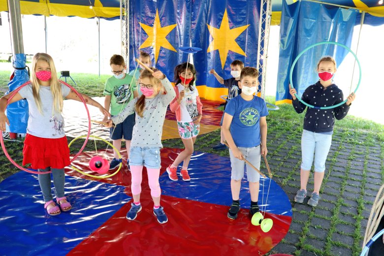 Auf dem Bild sieht man mehrere Kinder die Hula Hup machen  