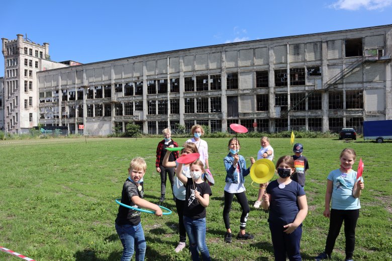 Auf diesem Bild sieht man mehrere Personen die vor einem alten Verlassenen Gebäude stehen 