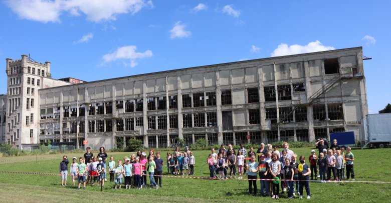 Auf diesem Bild sieht man mehrere Personen die vor einem alten Verlassenen Gebäude stehen 