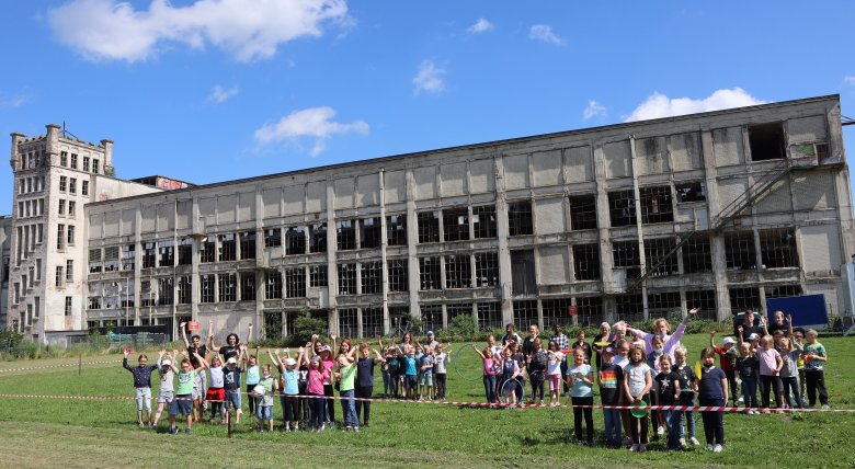 Auf diesem Bild sieht man mehrere Personen die vor einem alten Verlassenen Gebäude stehen 