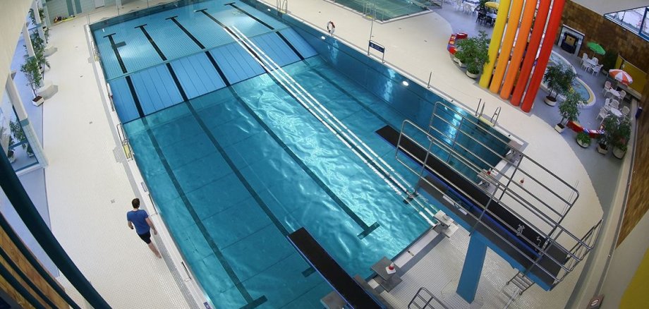 Vogelperspektive des Gronauer Hallenbads, die zwei Sprungbretter und ein großes Schwimmbecken zeigt.