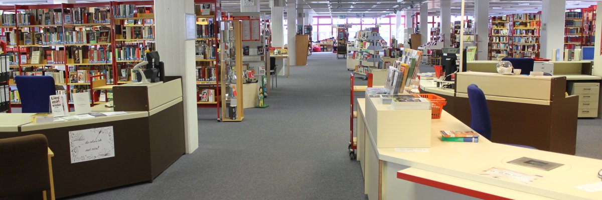 Büchereieingang in Gronau Eingangsbereich der Stadtbücherei in Gronau mit Blick von der Eingangstür auf einige Bücherregale und der Ausleihtheke in der Front.