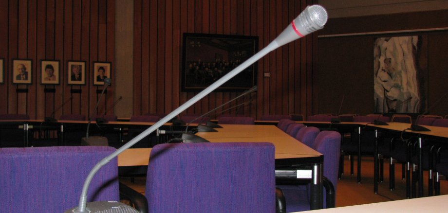 Ein Mikrofon auf einem Tisch im Sitzungssaal.