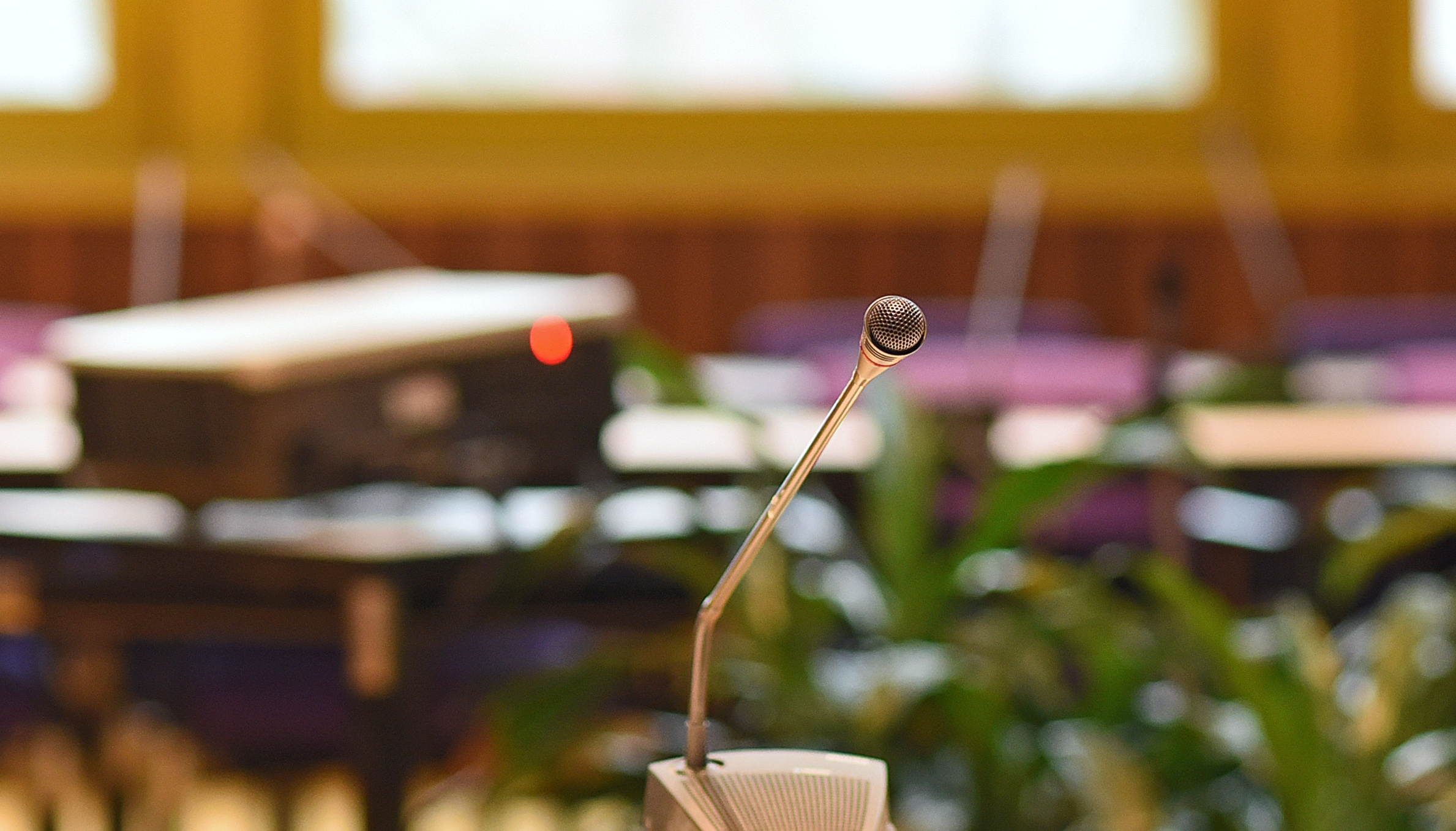 Das Bild zeigt das Mobilar im Sitzungsraum mit einem Mikrofon auf dem Tisch