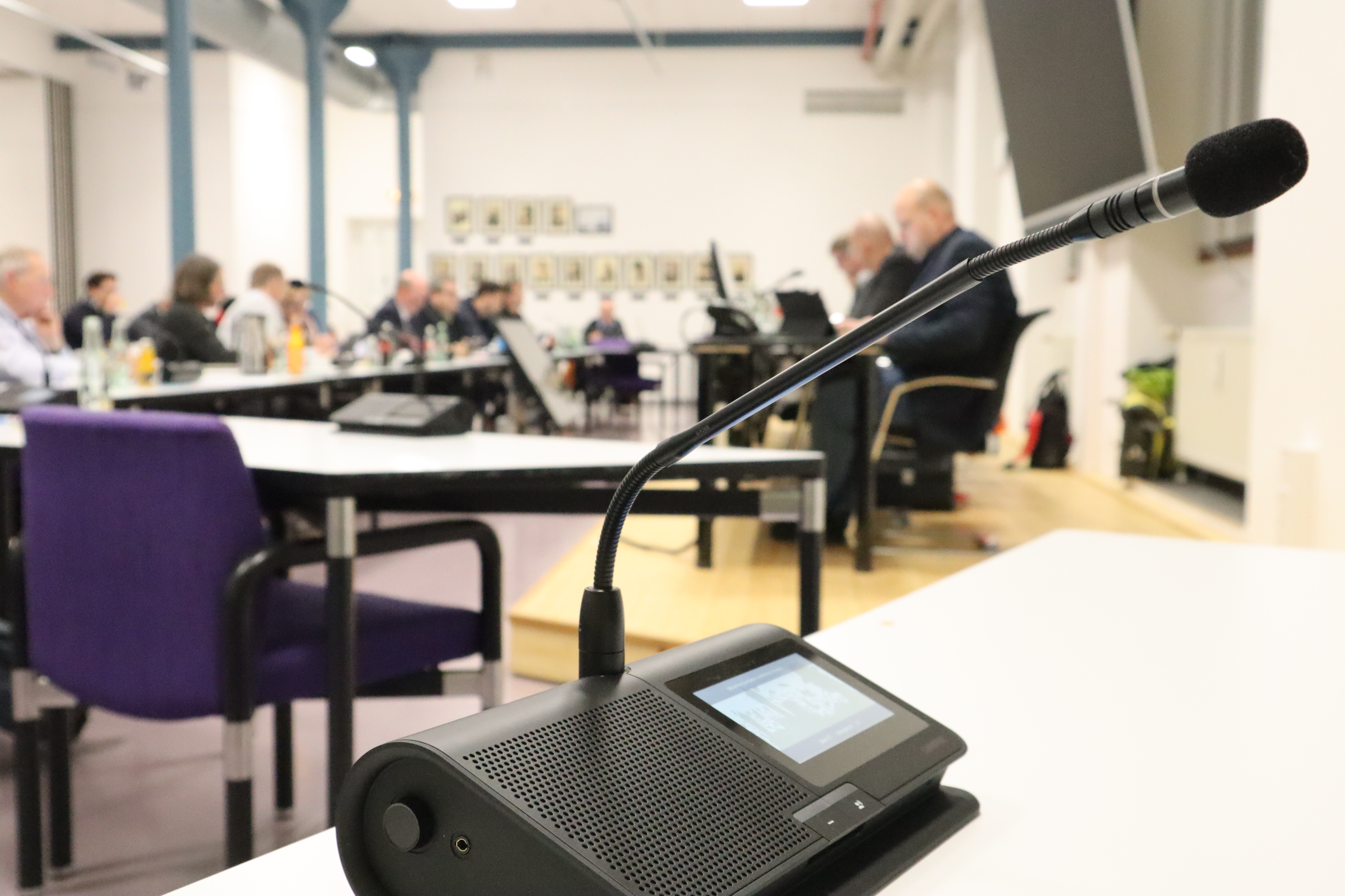 Mikrofon im Vordergrund des Ratssaals