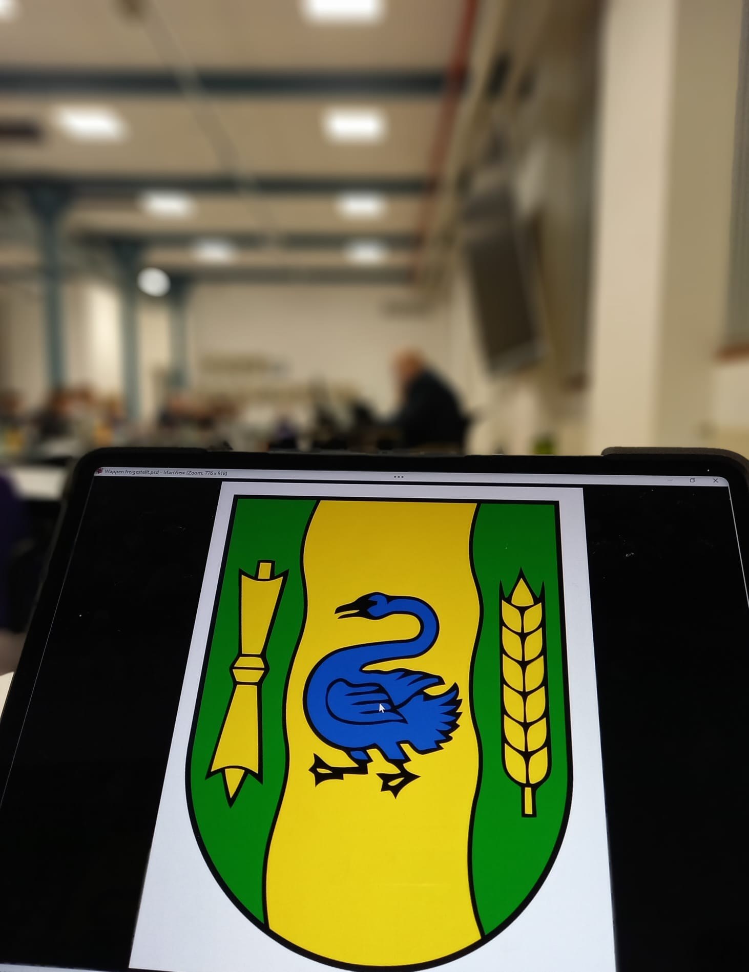 Das Wappen der Stadt Gronau mit dem Ratssaal im Hintergrund