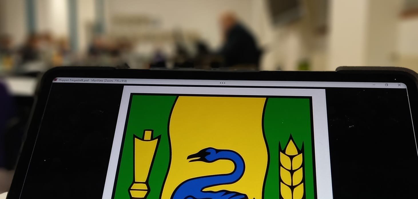 Das Wappen der Stadt Gronau mit dem Ratssaal im Hintergrund