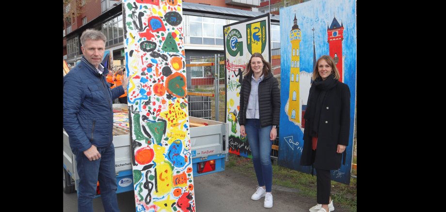 Der Bürgermeister mit Katharina Vater und Alina Epping stehe vor den Bildern des Kunstprojekts 