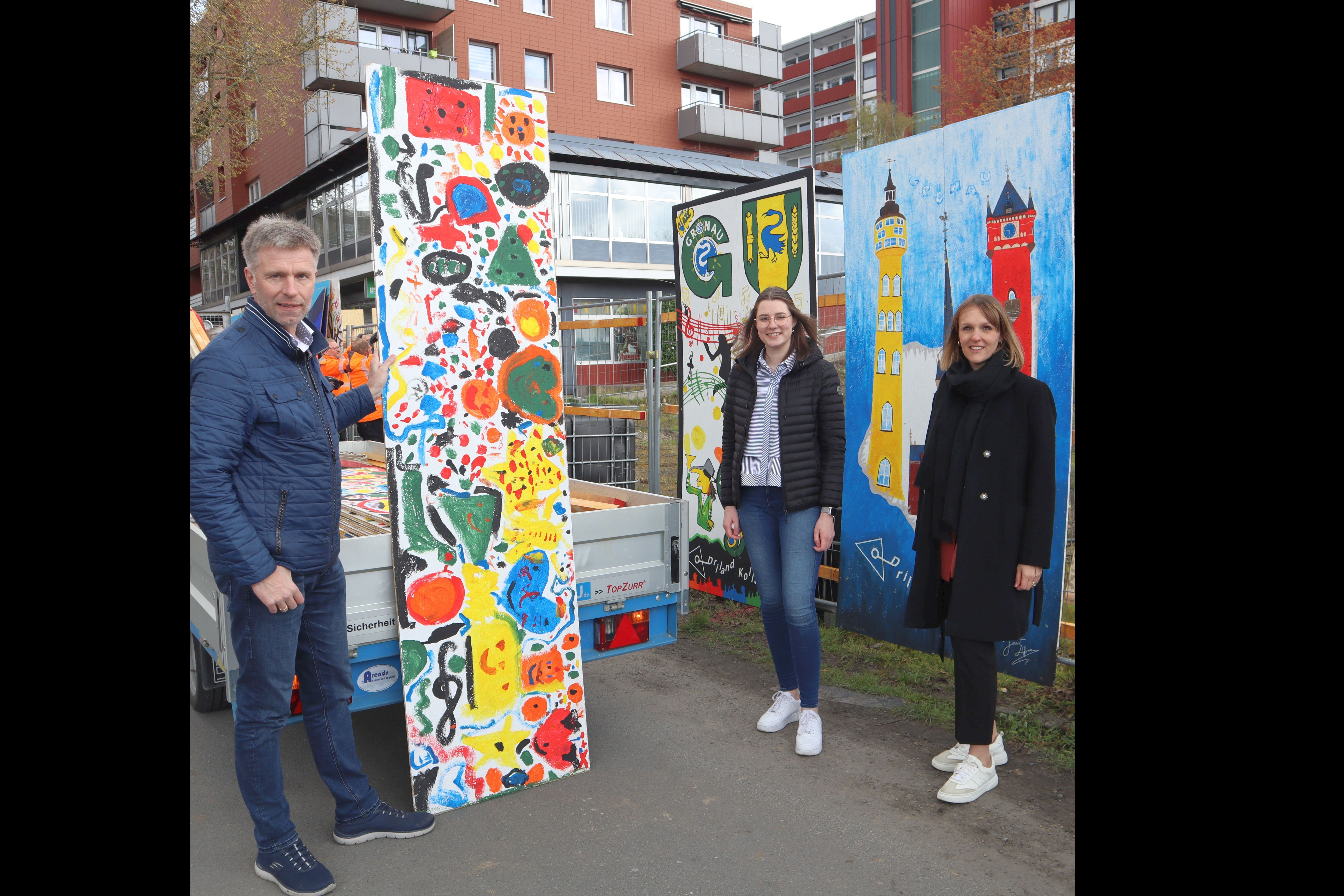 Der Bürgermeister mit Katharina Vater und Alina Epping stehe vor den Bildern des Kunstprojekts 