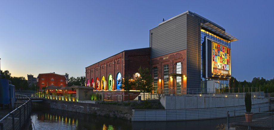 Blick auf das rock'n'popmuseum bei Nacht aus Richtung der Bahnhofstraße. Links im Bild kann man das Bamboo erkennen.