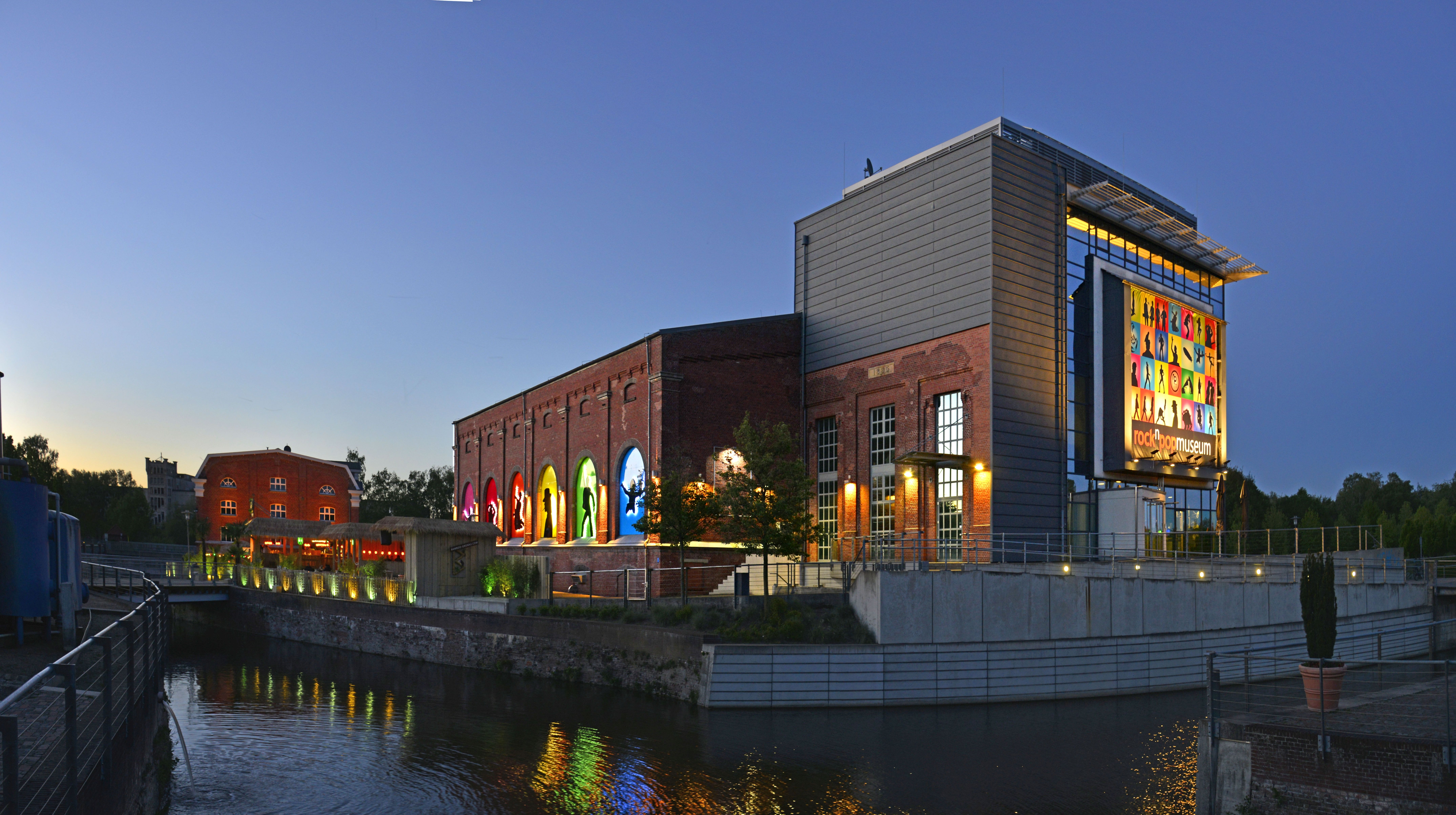 Blick auf das rock'n'popmuseum bei Nacht aus Richtung der Bahnhofstraße. Links im Bild kann man das Bamboo erkennen.