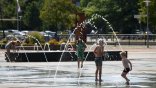 Wasserlabyrinth Drei Kinder von hinten die unter mehren Fontänen des Wasserlabyrinths umher springen.
