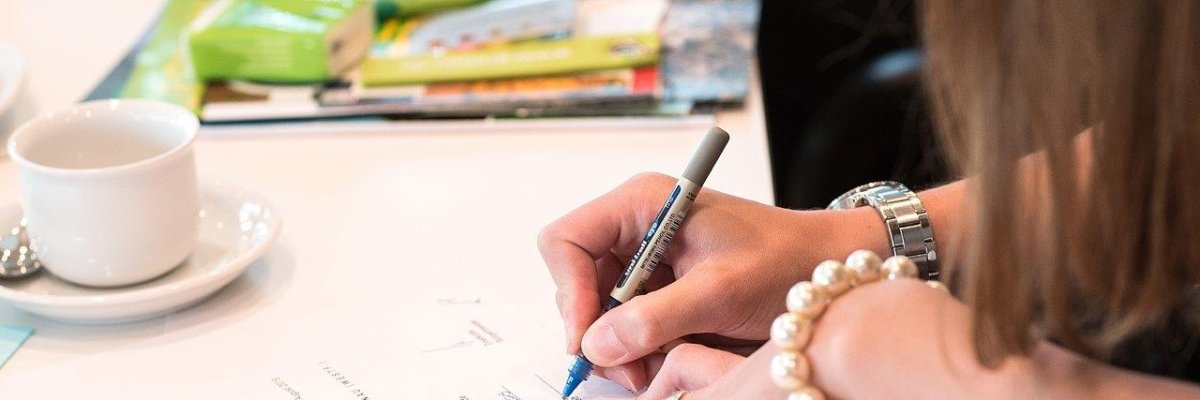 Eine Frau unterschreibt ein Dokument. Eine Frau unterschreibt ein Dokument.