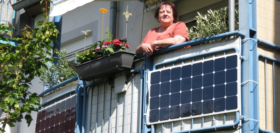 Frau an Balkon mit Stecker-Solaranlage