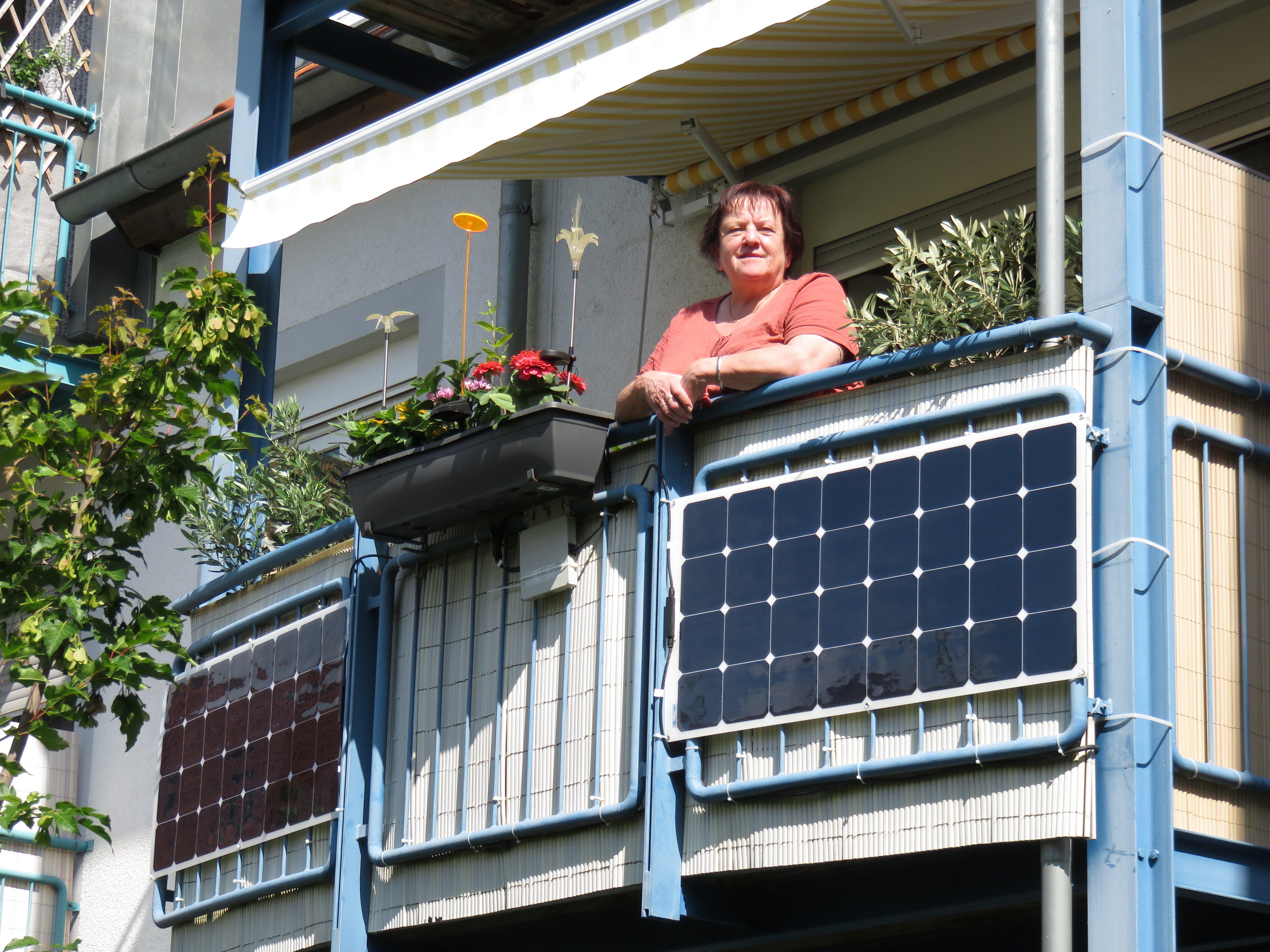 Frau an Balkon mit Stecker-Solaranlage