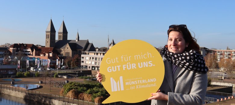 Frau mit Sprechblase "Gut für mich, gut für uns. Denn Münsterland ist Klimaland" vor dem LAGA-Gelände.