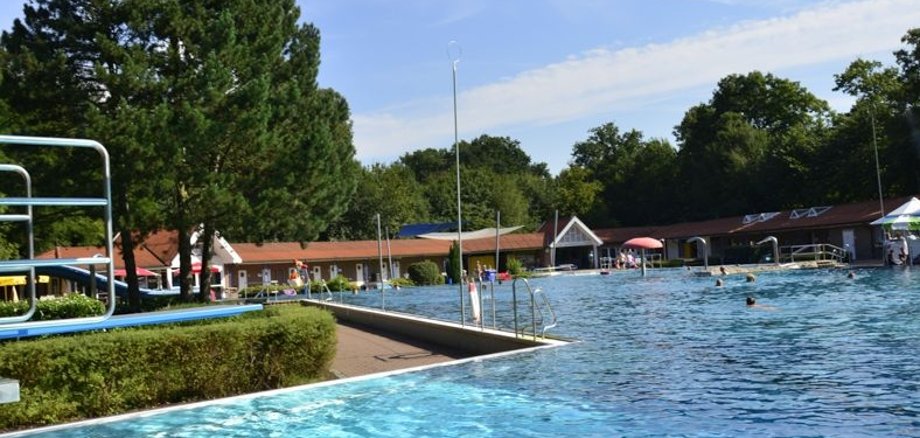 Ein Kind springt von einem Sprungbrett in ein Schwimmbecken.