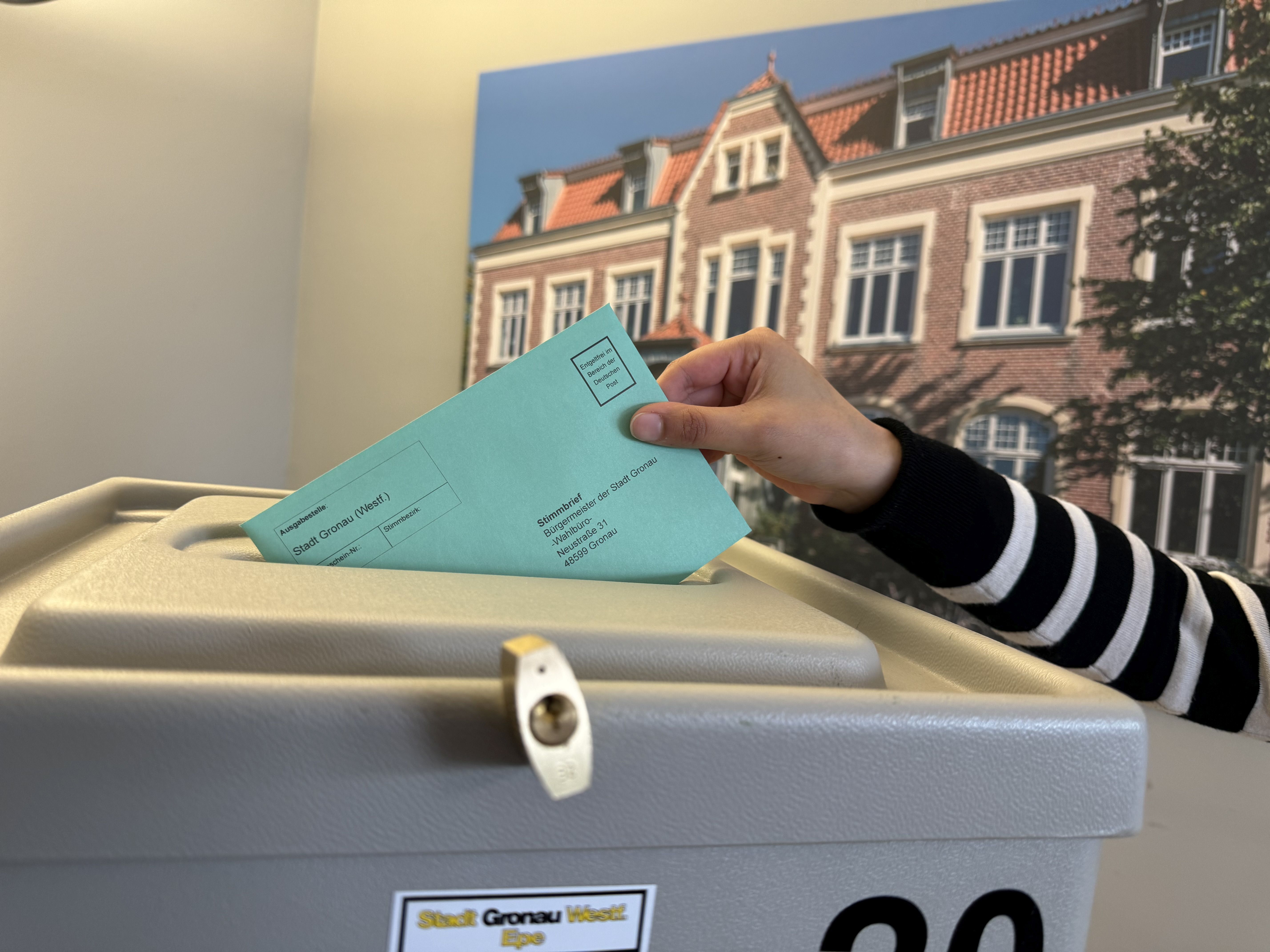 Ein Wahlbrief wird in Wahlurne gesteckt