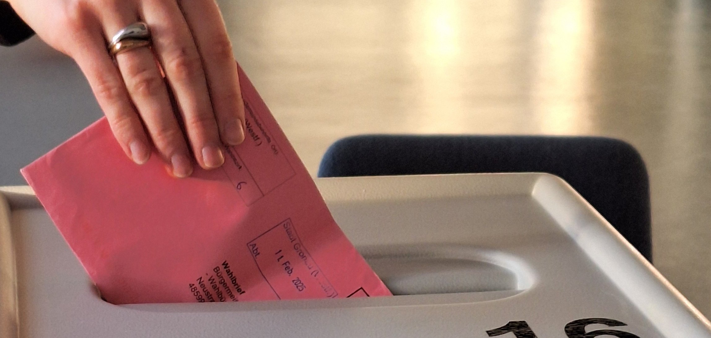 Ein Wahlbrief wird in die Wahlurne geworfen.