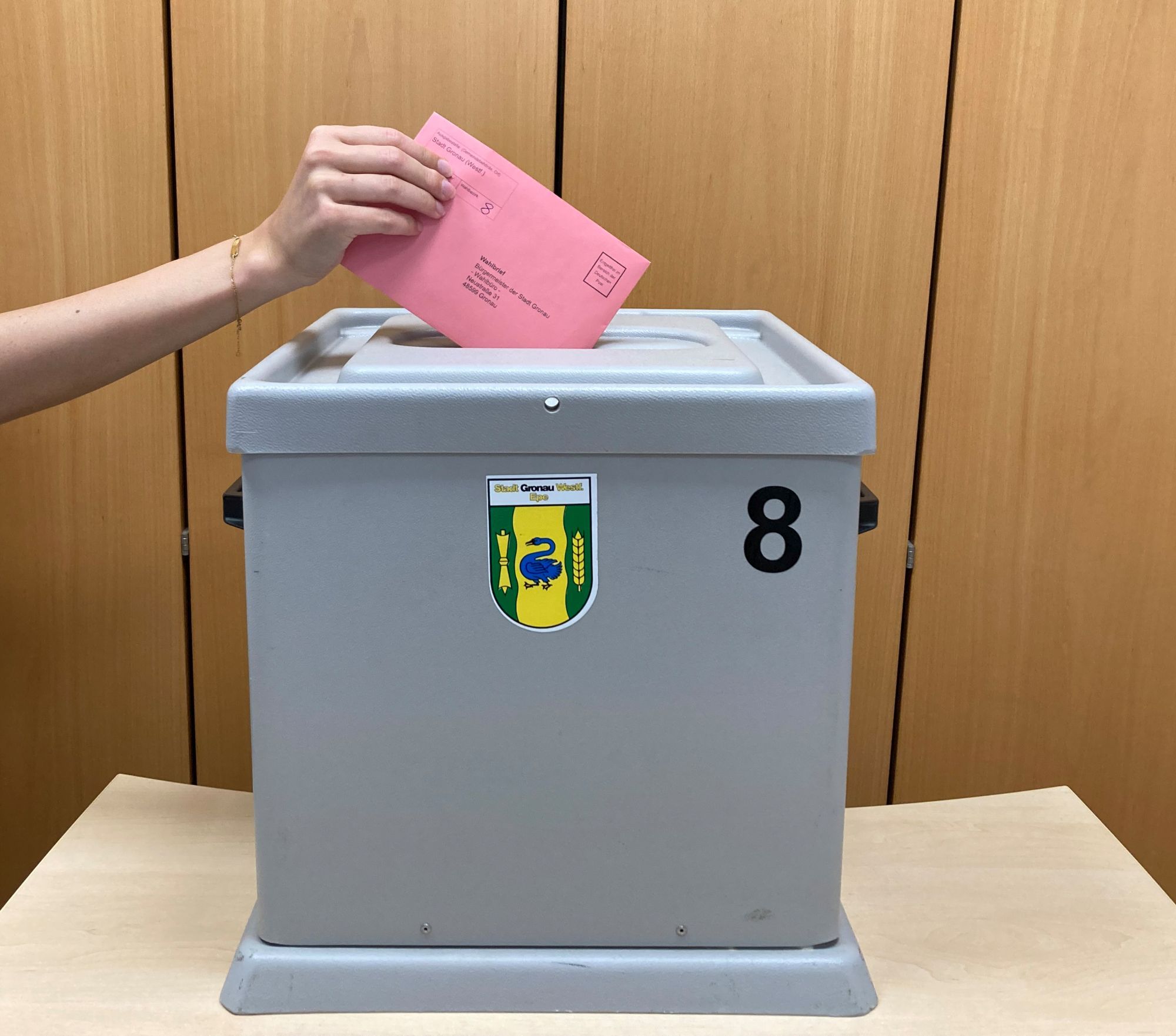 Ein Wahlzettel wird in die Wahlurne gesteckt.