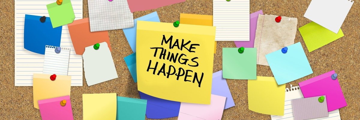 Pinnwand Eine Pinnwand mit vielen Zetteln, auf einem steht „make things happen“.