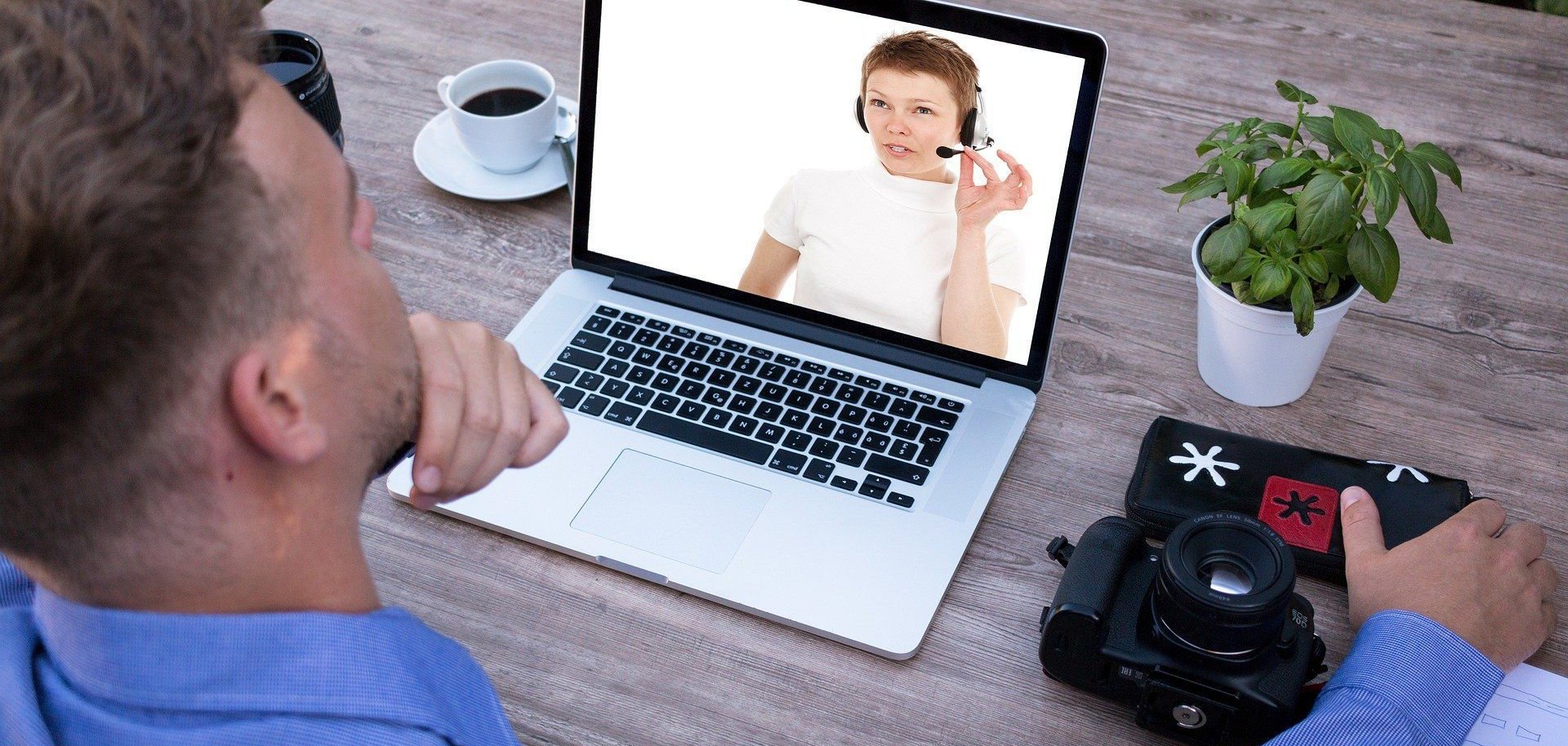 Ein Mann sitzt vor seinem Laptop und verfolgt ein Webinar.