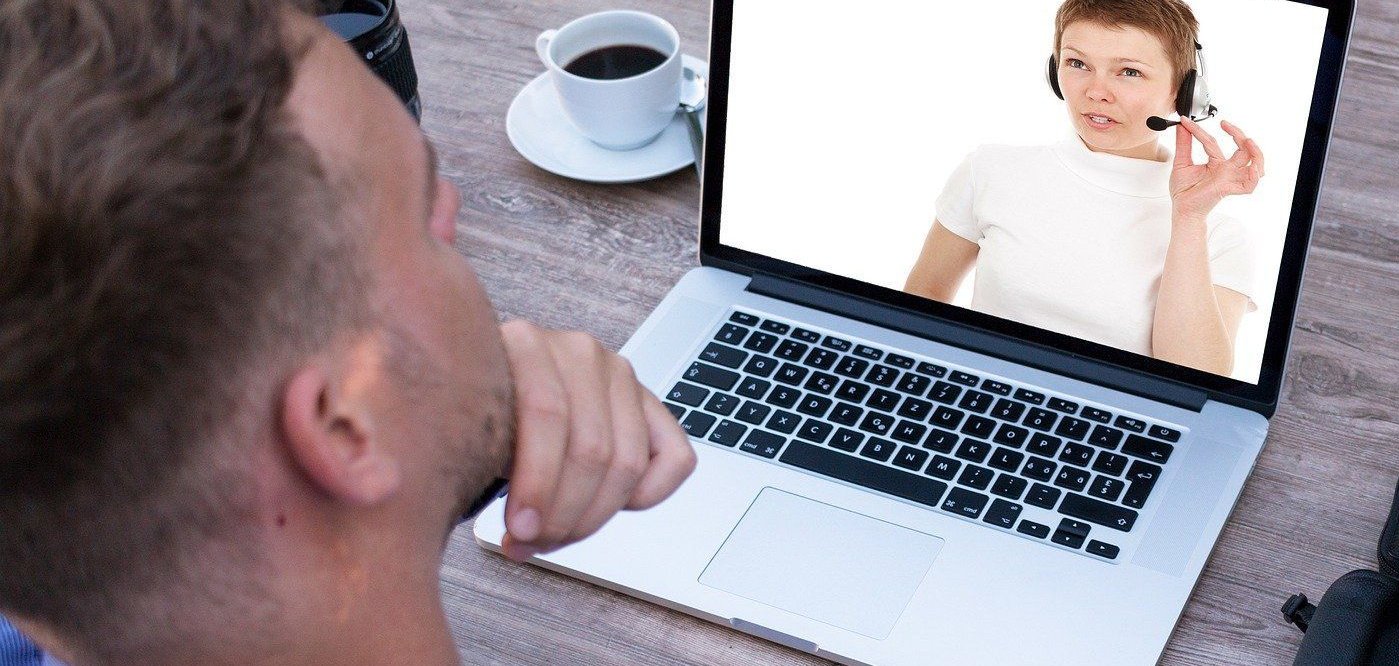 Webinar Ein Mann sitzt vor seinem Laptop und verfolgt ein Webinar.