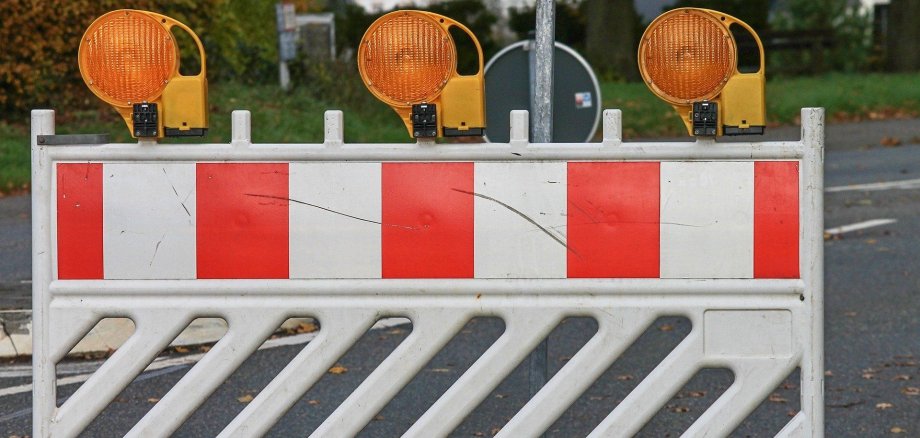 Eine Baustellenabsperrung steht auf einer Straße.