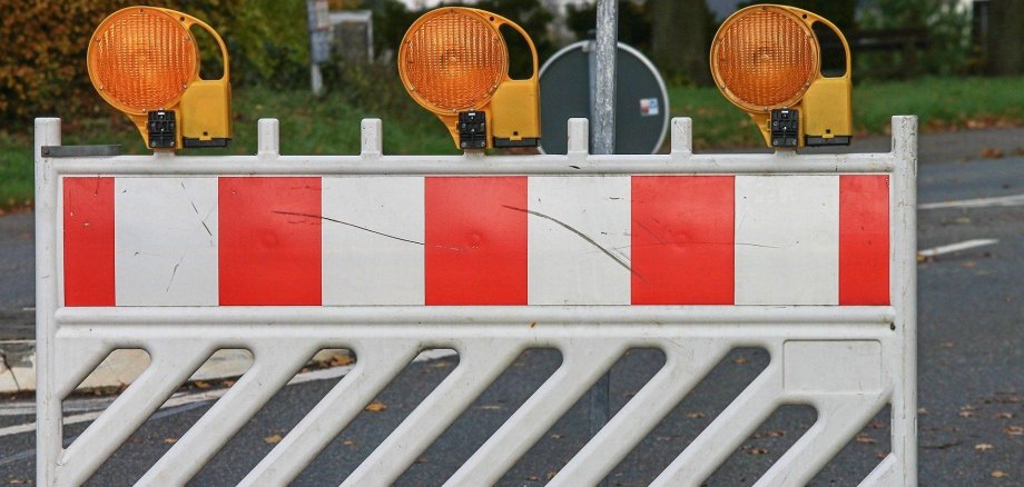 Eine Baustellenabsperrung steht auf einer Straße.