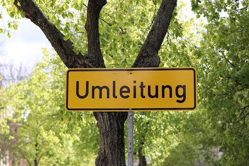 Man sieht ein Umleitungsschild vor einem Baum.