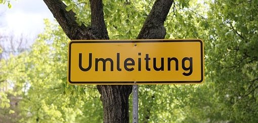 Man sieht ein Umleitungsschild vor einem Baum.