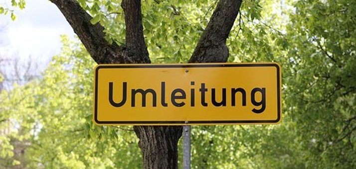 Man sieht ein Umleitungsschild vor einem Baum.