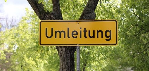 Man sieht ein Umleitungsschild vor einem Baum.