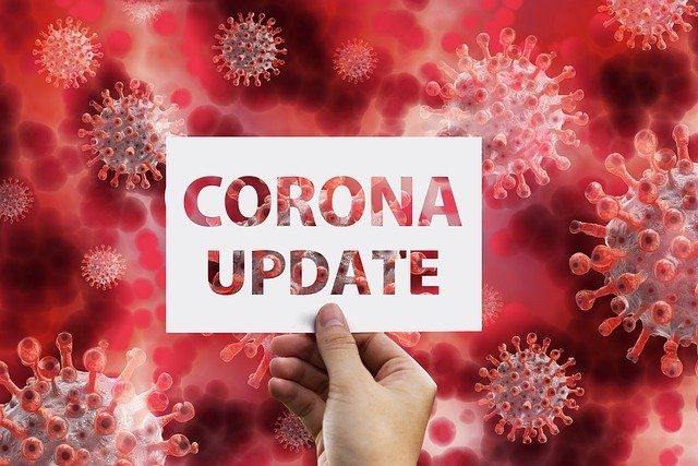 Im Hintergrund das Coronavirus, im Vordergrund das Schild „Corona-Update“.