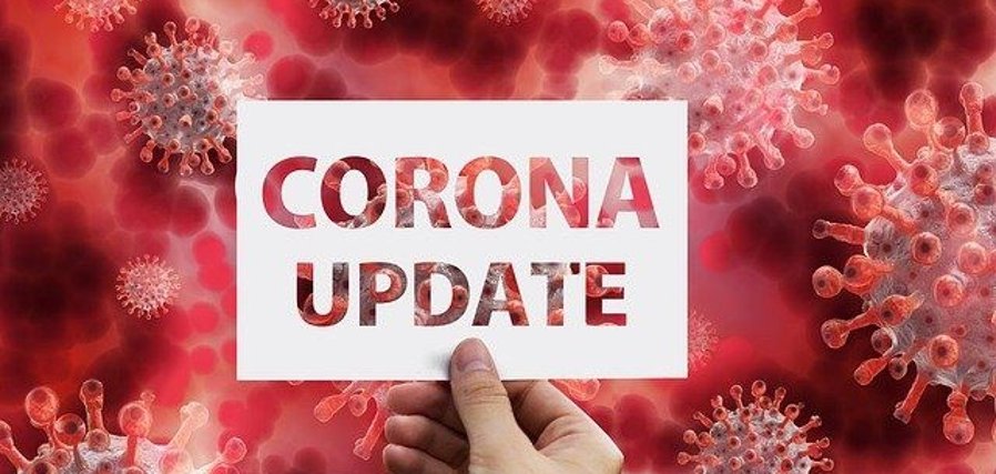 Im Hintergrund das Coronavirus, im Vordergrund das Schild „Corona-Update“.