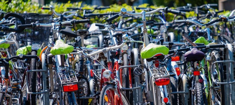 Viele Fahrräder stehen durcheinander an Fahrradständern.