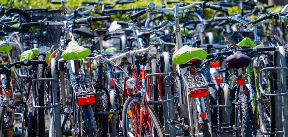 Viele Fahrräder stehen durcheinander an Fahrradständern.