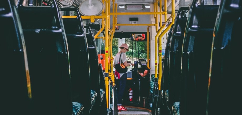 Eine Frau bezahlt im Bus.