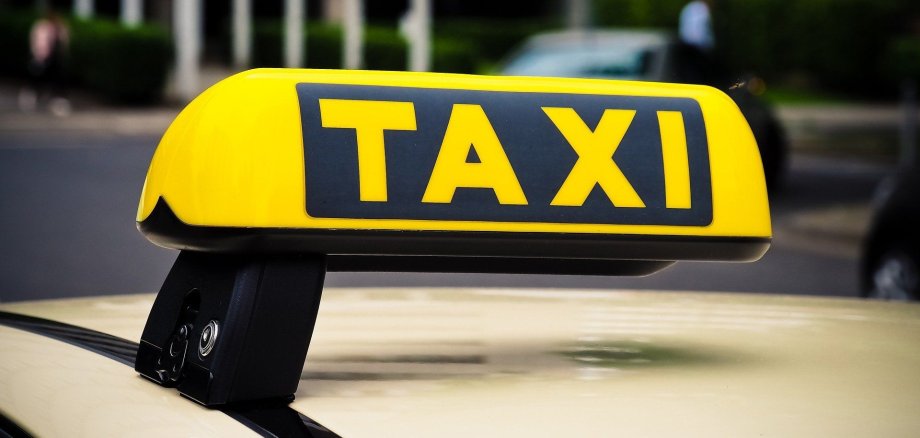 Ein Taxi-Schild auf einem Taxidach.