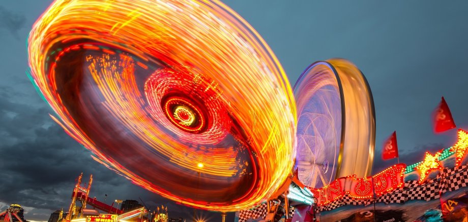 Ein beleuchteter Jahrmarkt am Abend.