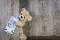 Ein Teddy hält einen 20-Euro-Schein in der Hand.