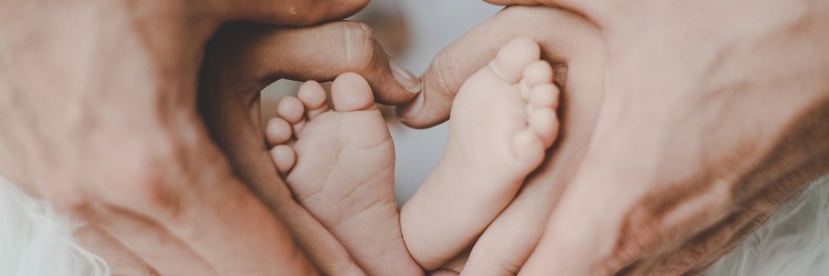 Babyfüßchen, die von den Eltern eingerahmt werden.