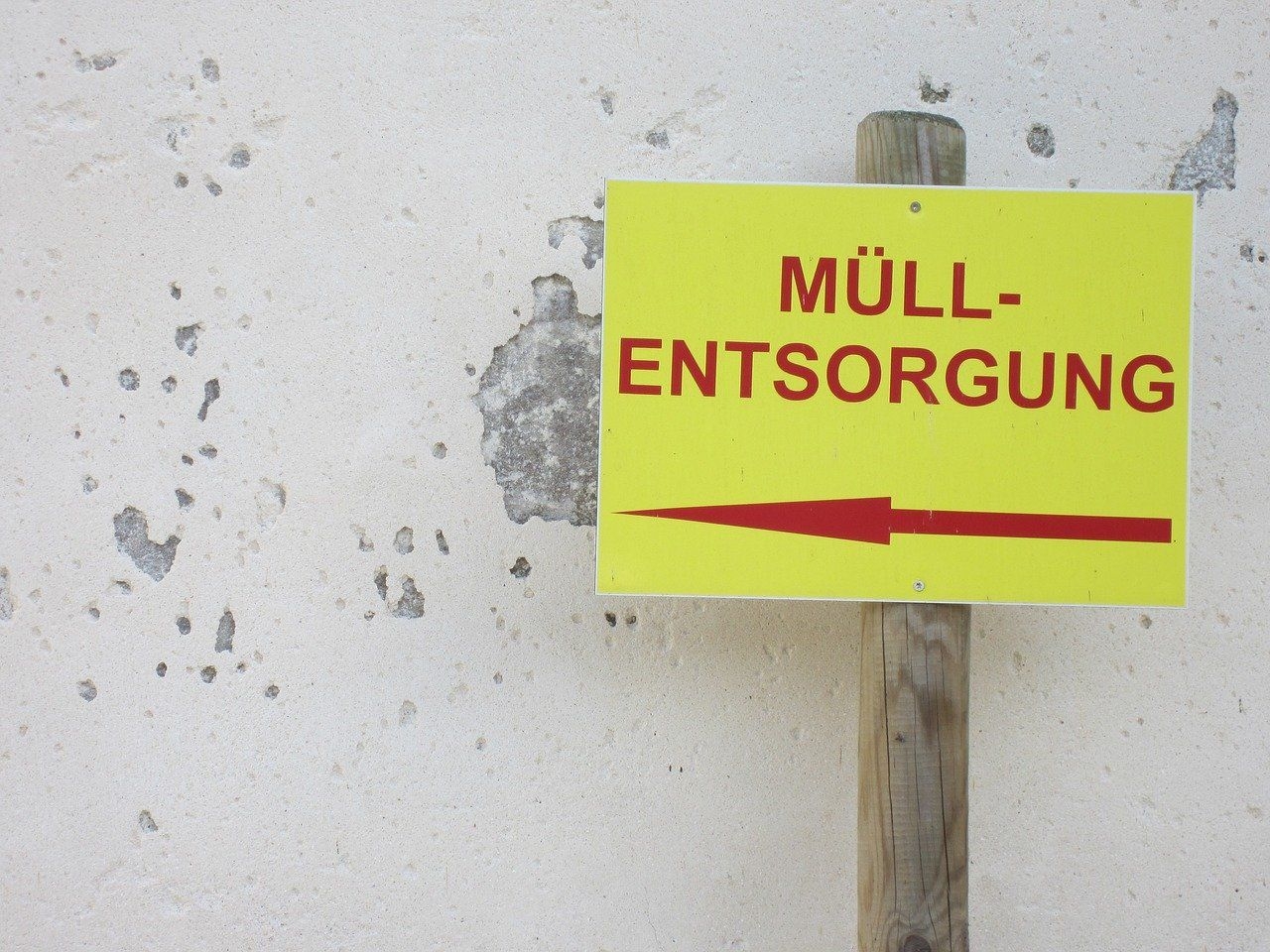 Ein Schild mit der Aufschrift „Müllentsorgung“ und einem Pfeil nach links.