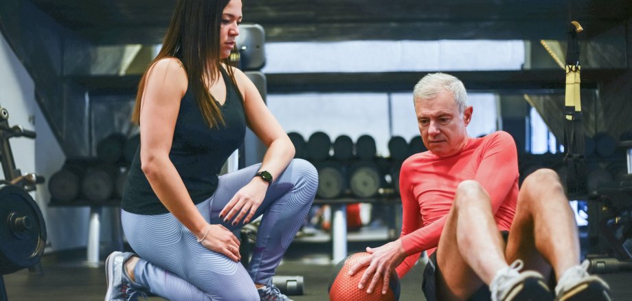 Ein Senior bekommt Fitness-Unterricht.