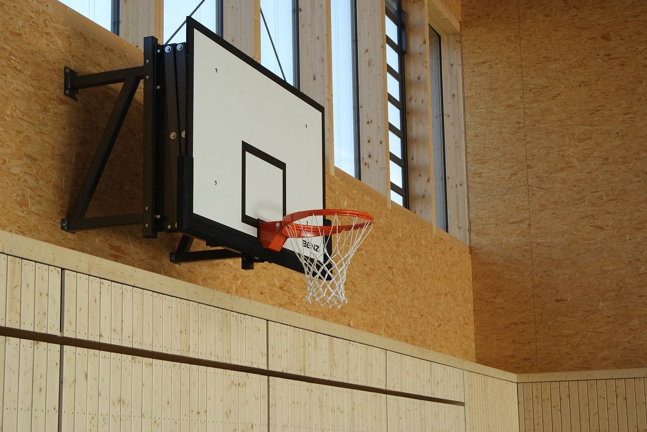 Basketballkorb der an der Wand einer Sporthalle hängt