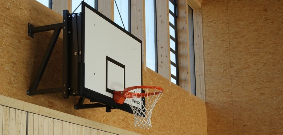 Basketballkorb der an der Wand einer Sporthalle hängt