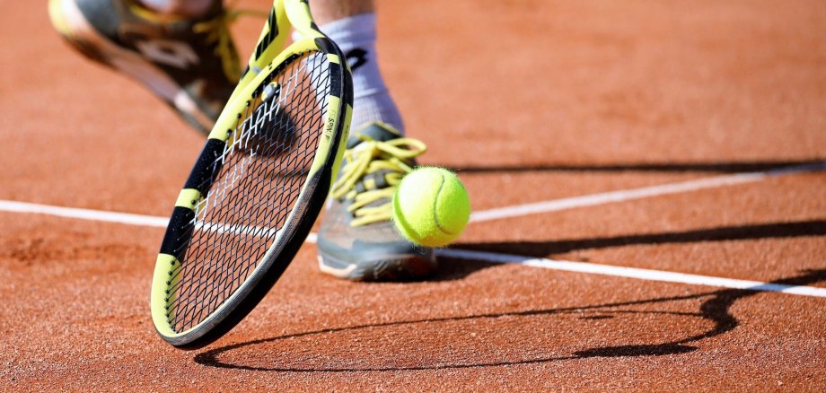 Eine Person spielt Tennis auf einem Tennisplatz.