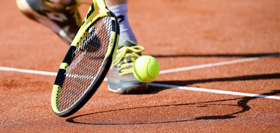 Eine Person spielt Tennis auf einem Tennisplatz.