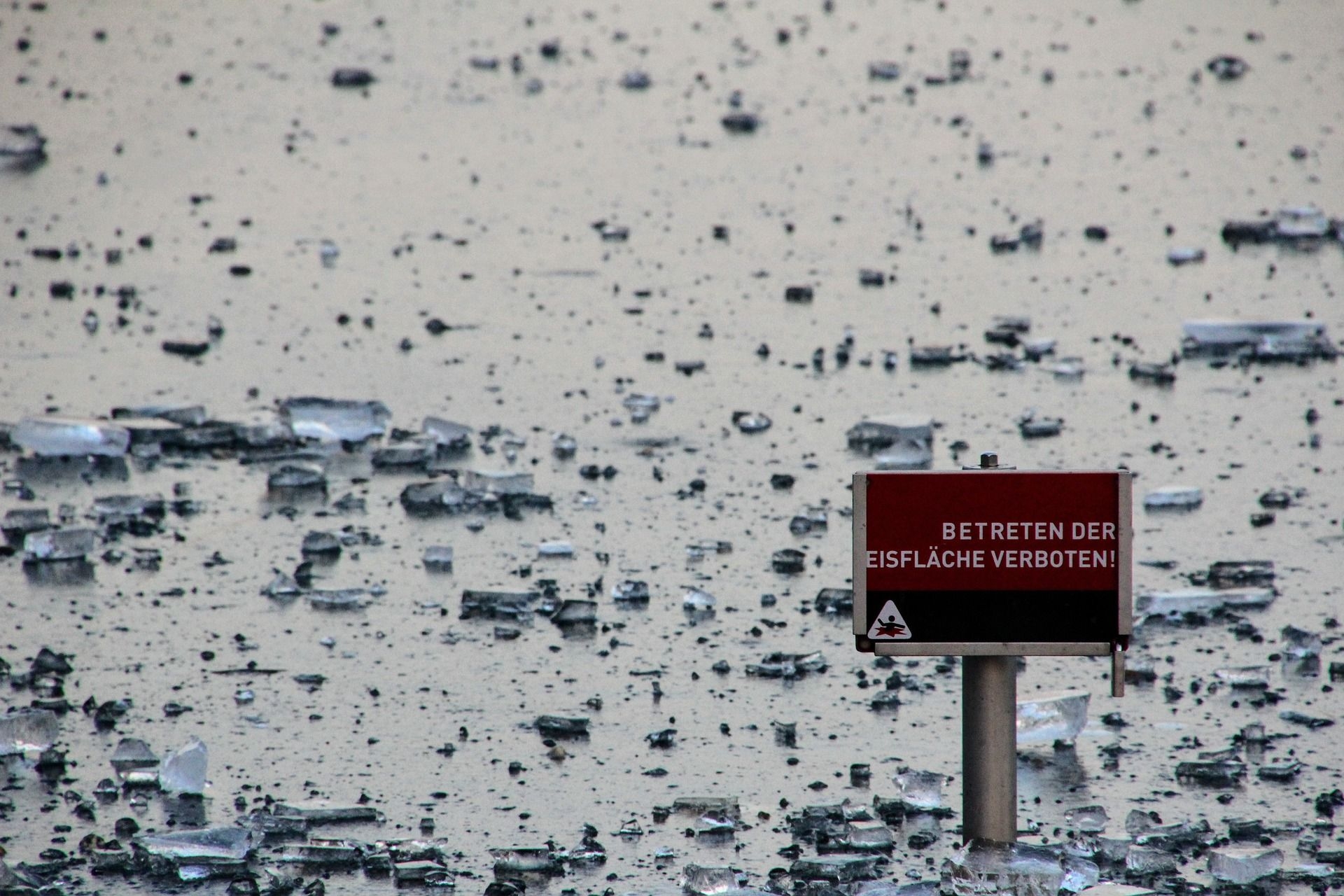 Auf einer zugefrorenen Eisfläche steht das Schild „Betreten der Eisfläche verboten!“.